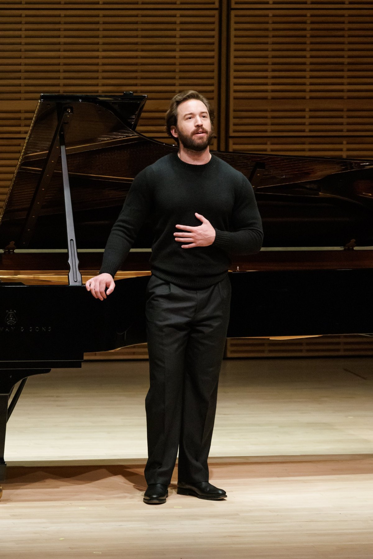 Michael Hewitt singing a recital beside a grand piano
